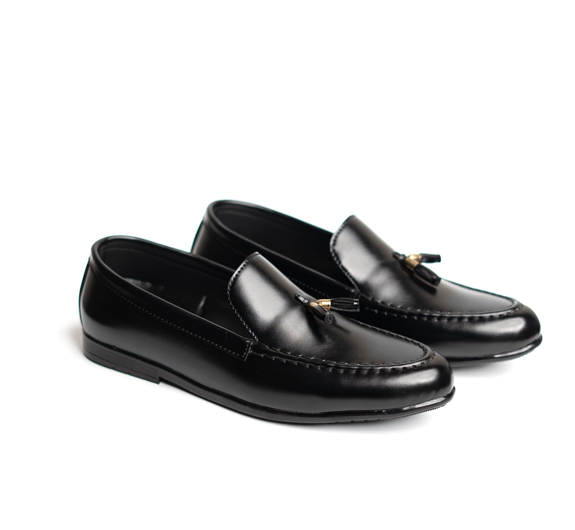 Pair of black loafers with tassels on a white background