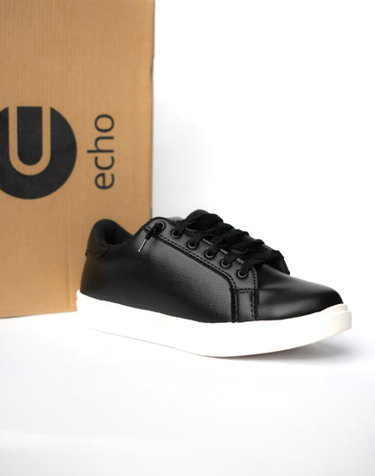 Black sneaker with white sole in front of an 'echo' branded box on a white background