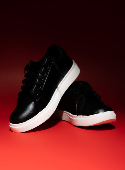 Black sneakers with white soles on a red background
