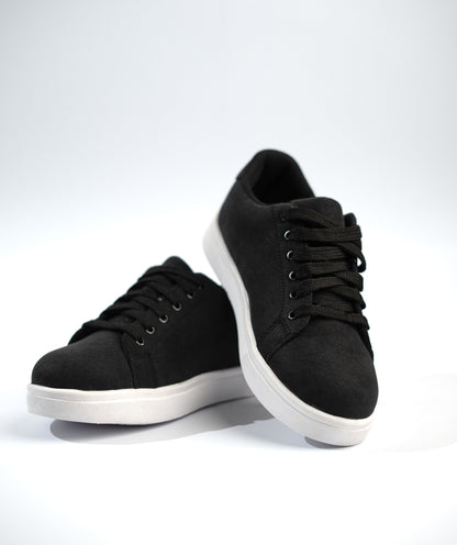 Black sneakers with white soles on a light gray background