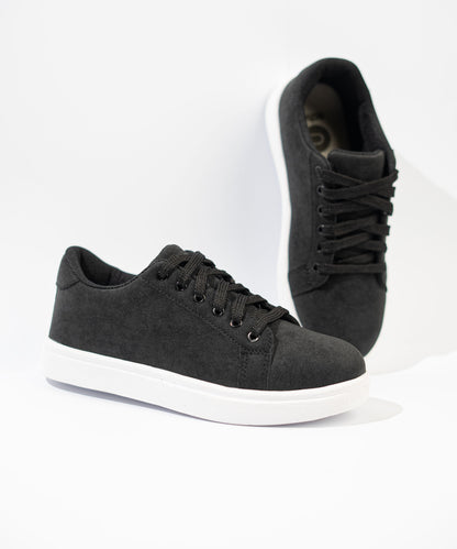 Black sneakers with white soles on a light gray background