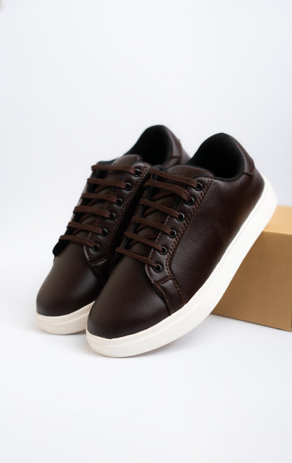 Pair of brown sneakers with white soles on a light gray background
