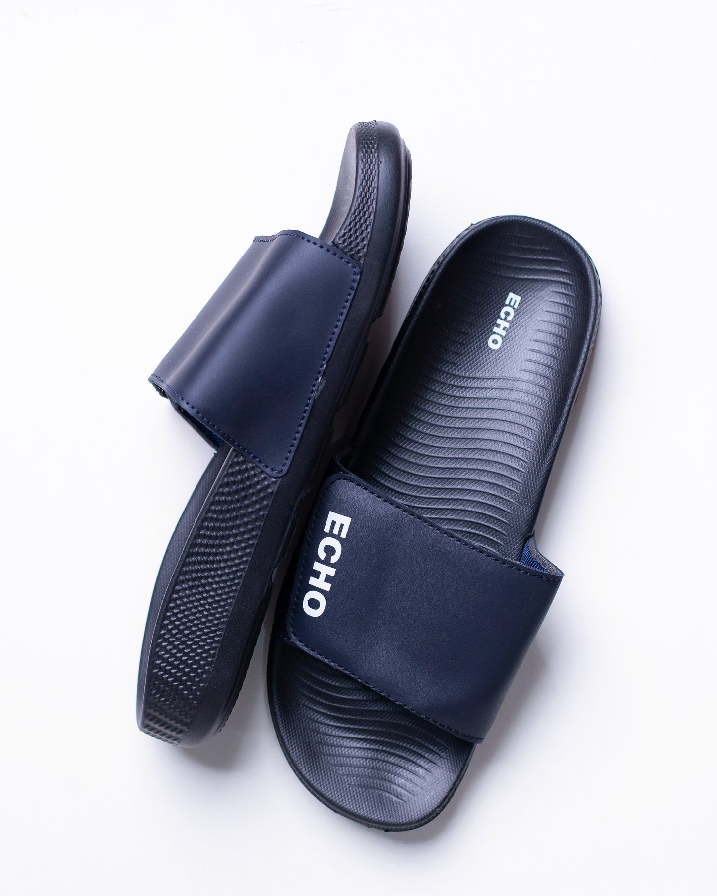 Pair of navy blue slides with 'Echo' branding on a white background