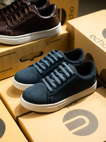 Blue sneakers on Echo brand boxes with a brown shoe in the background