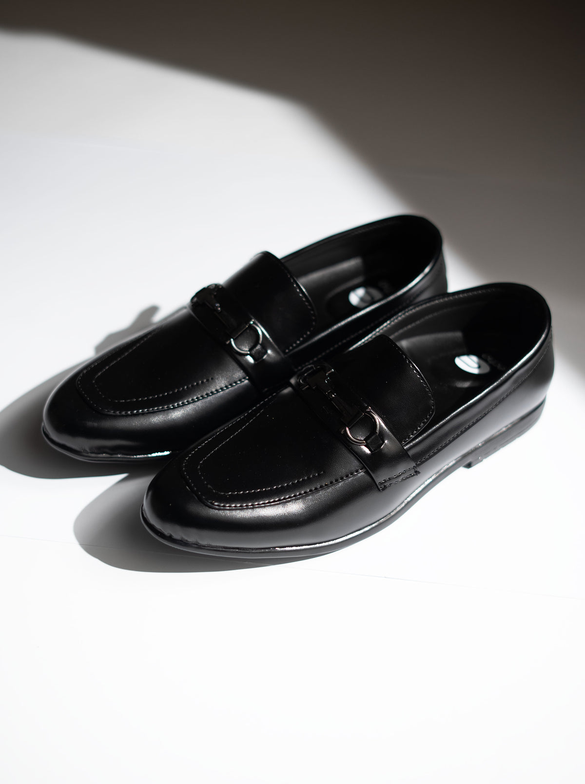 Pair of black loafers on a white background