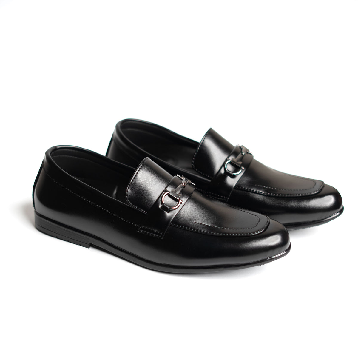 Pair of black loafers with a silver buckle on a white background