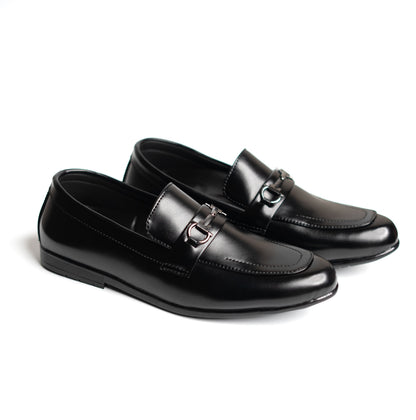 Pair of black loafers with a silver buckle on a white background