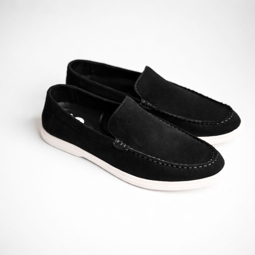 Pair of black loafers on a white background