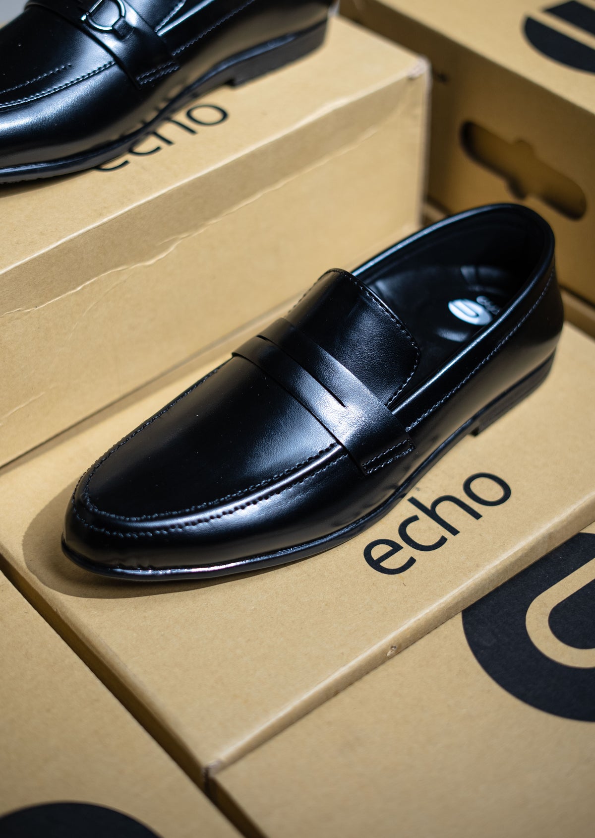 Black loafer shoe on an 'echo' branded box