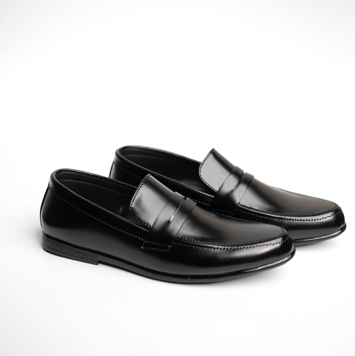 Pair of black loafers on a white background