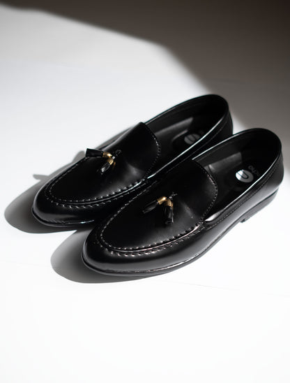 Pair of black loafers on a white background