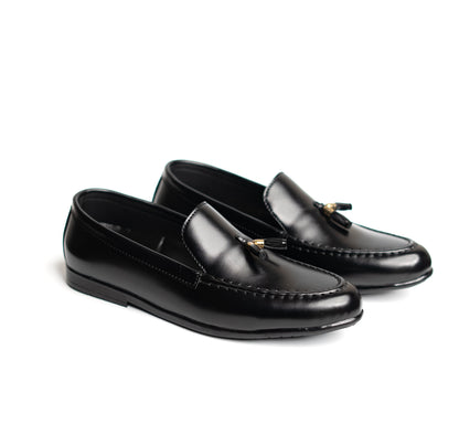 Pair of black loafers with tassels on a white background