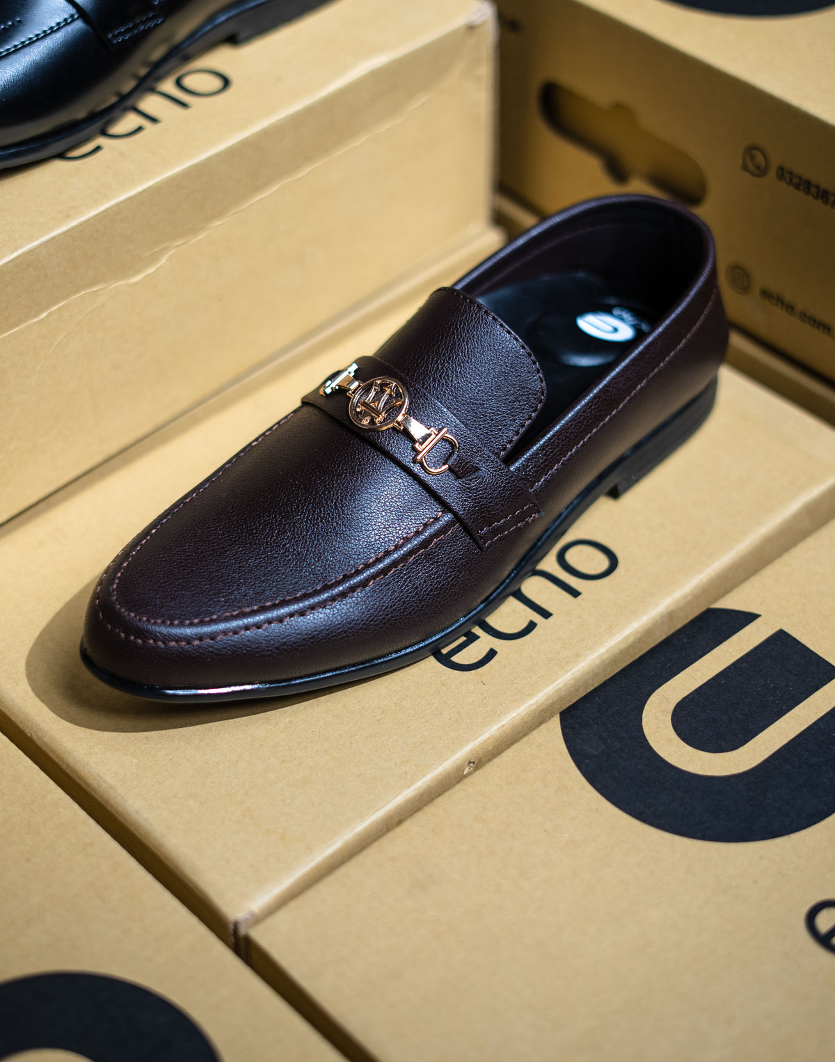 Dark brown leather loafer on a beige box with 'Ucon' branding.