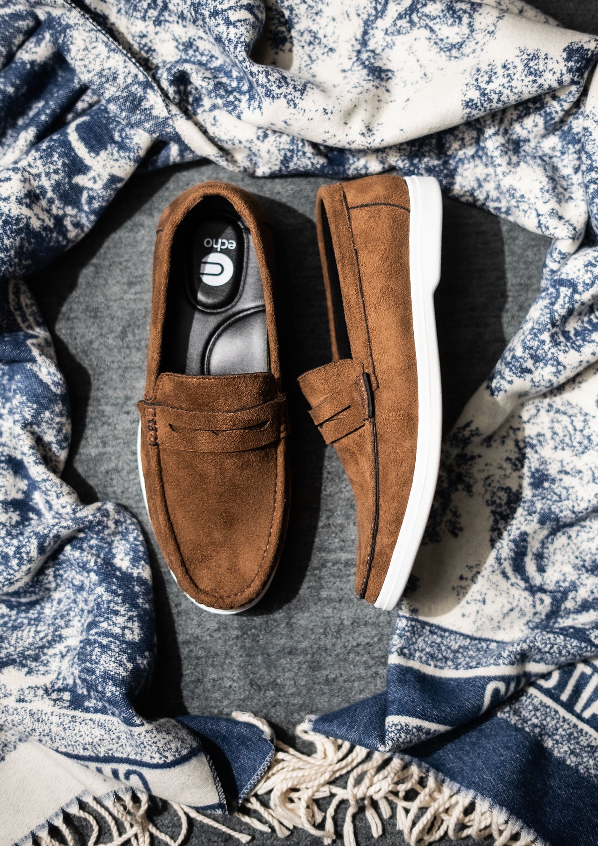 Brown loafers on a textured fabric background