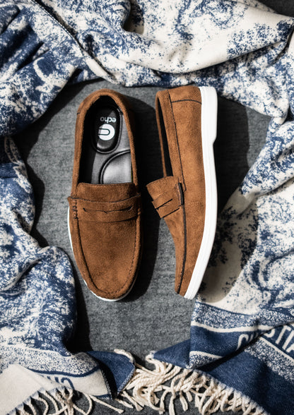 Brown loafers on a textured fabric background