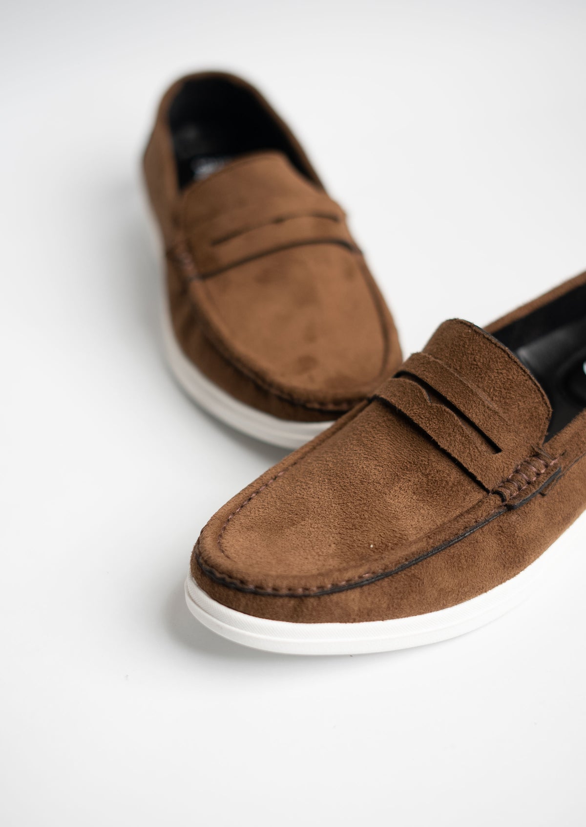 Brown suede loafers on a white background