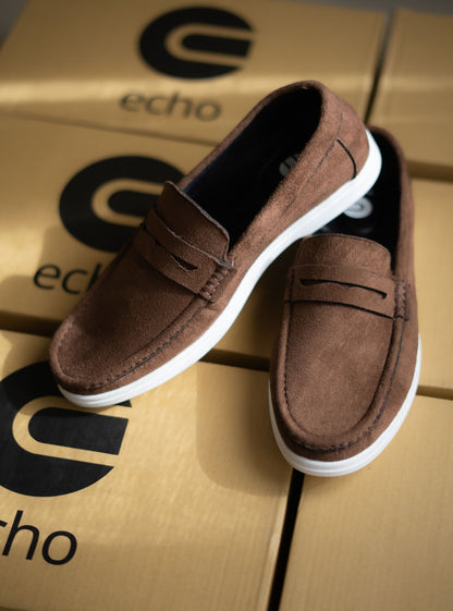 Brown loafers on a cardboard box with 'echo' branding
