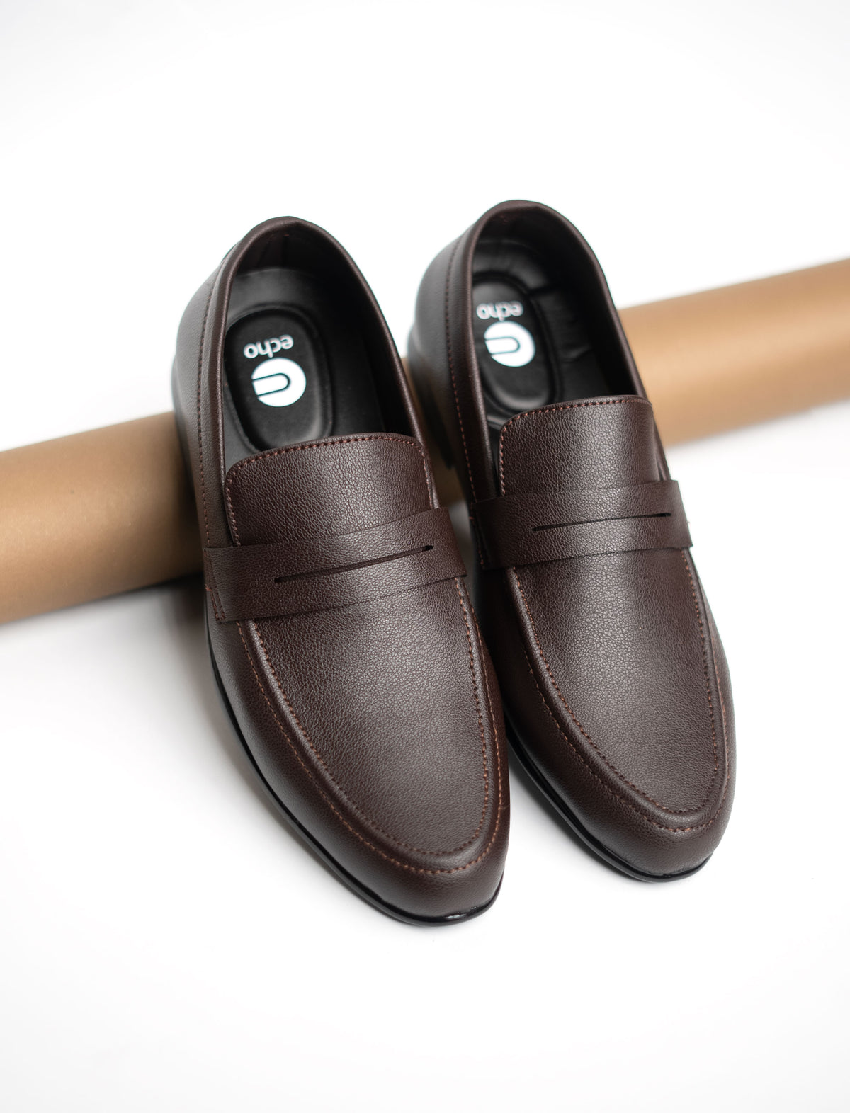 Pair of brown leather loafers on a white background