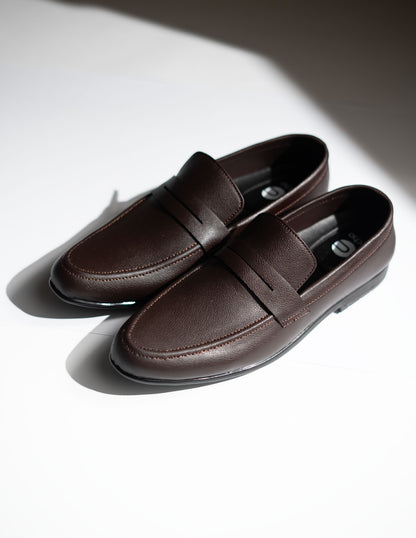 Pair of brown loafers on a light background