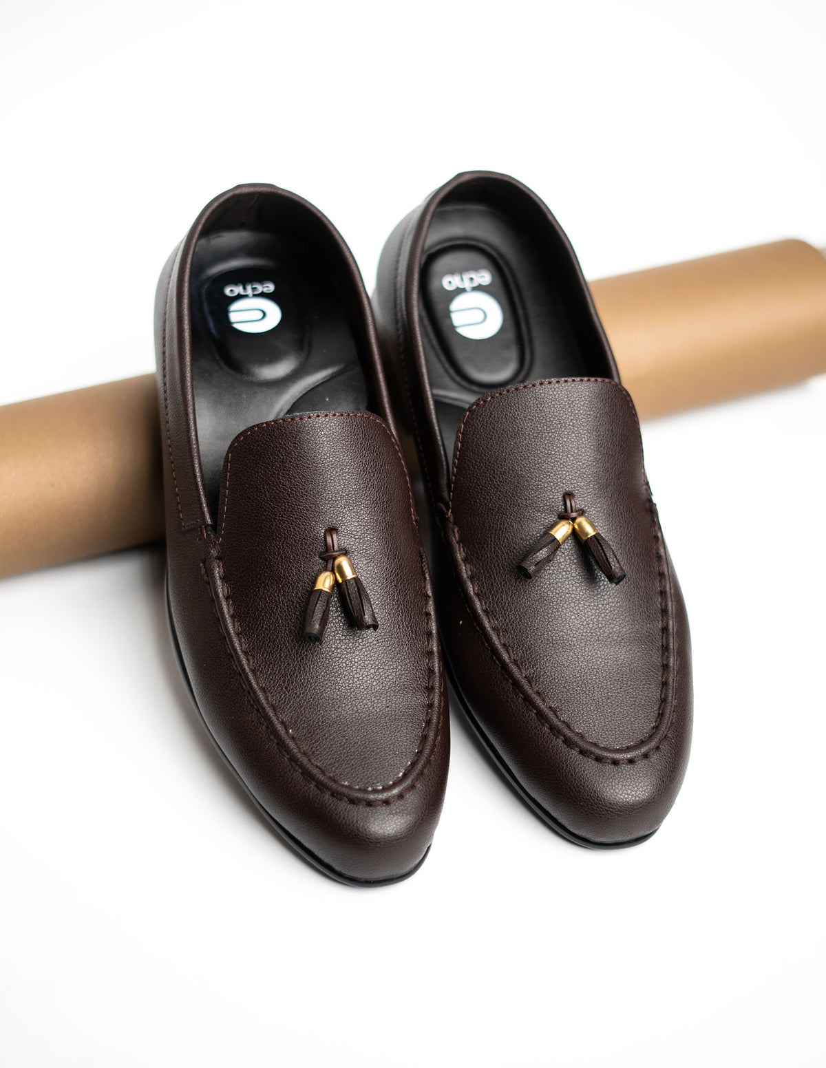 Pair of brown loafers with tassels on a white background