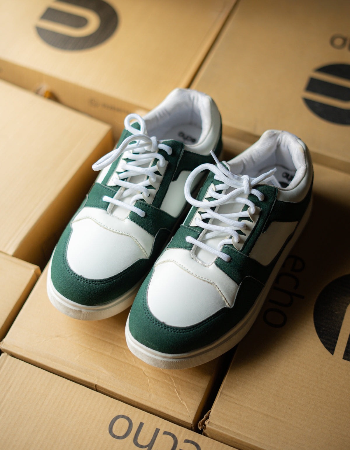 Green and white sneakers on a cardboard box