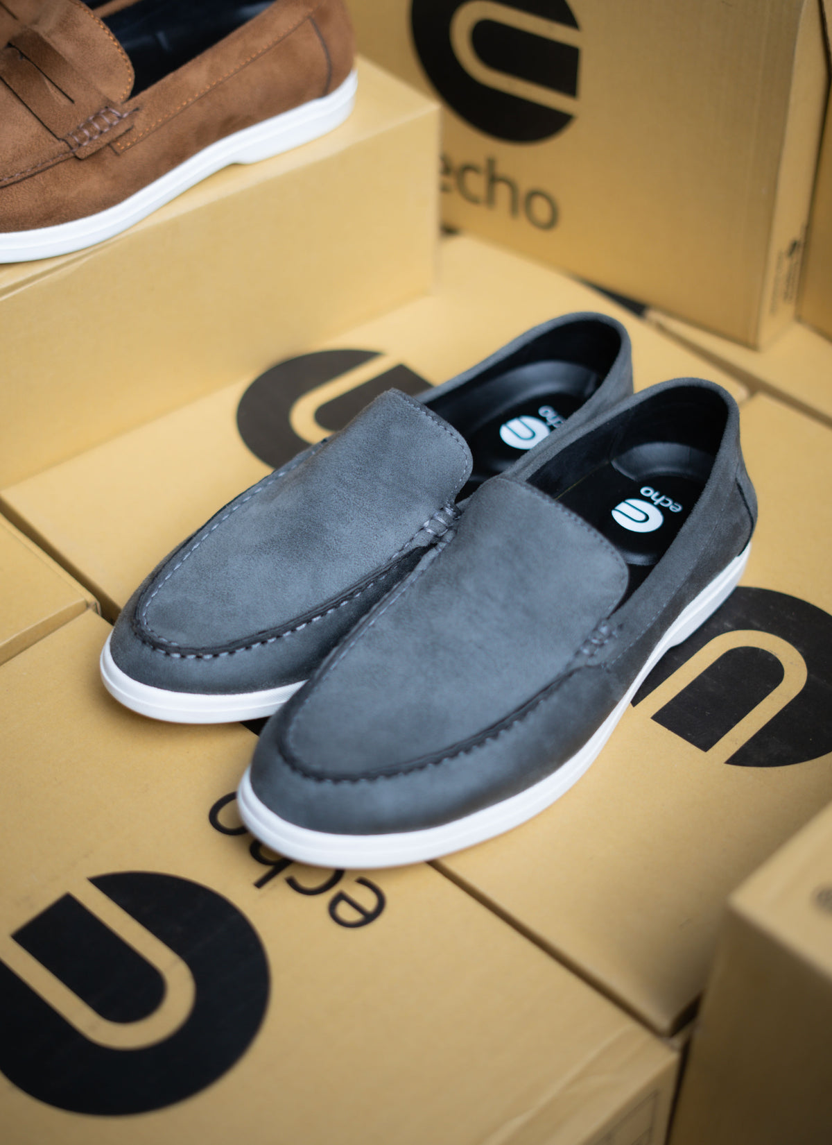 Gray loafers on a cardboard box with 'echo' branding