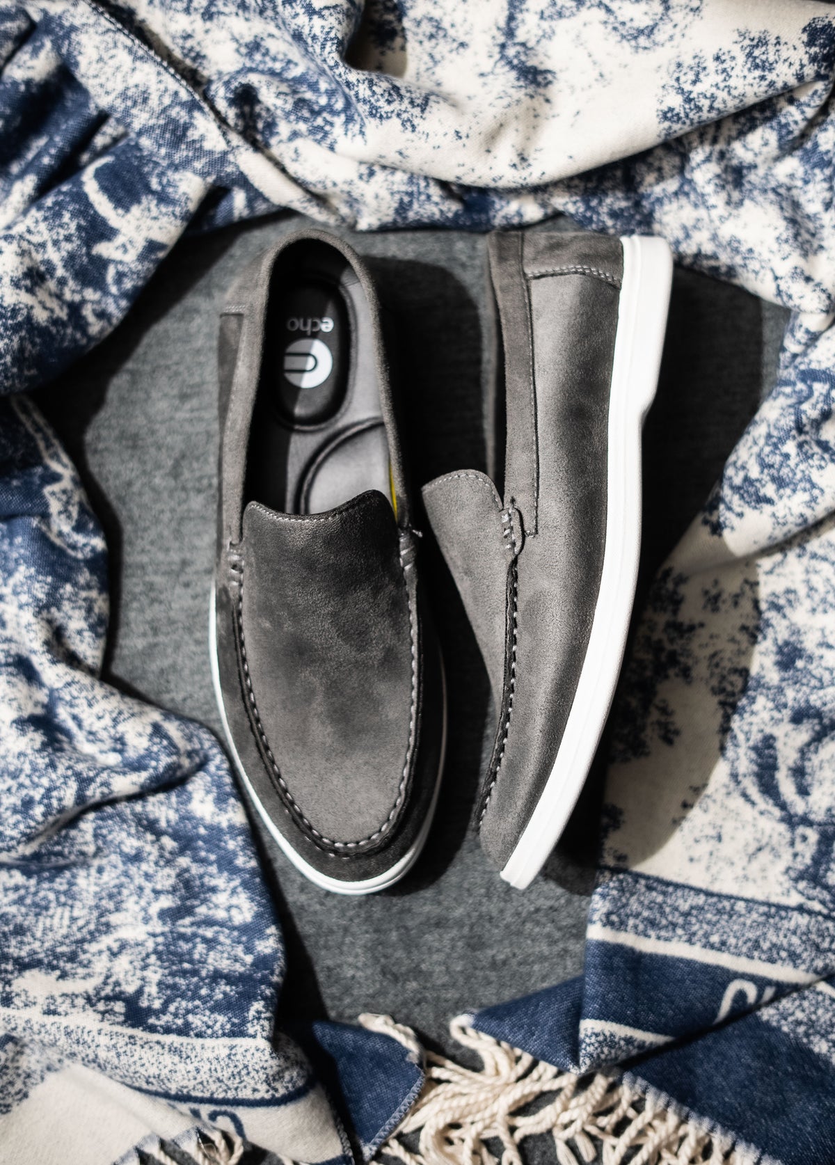 Gray loafers on a textured fabric background