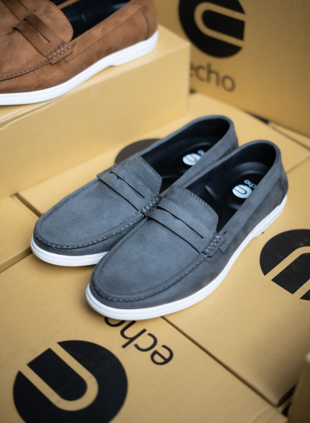Gray loafers on a cardboard box with 'echo' branding