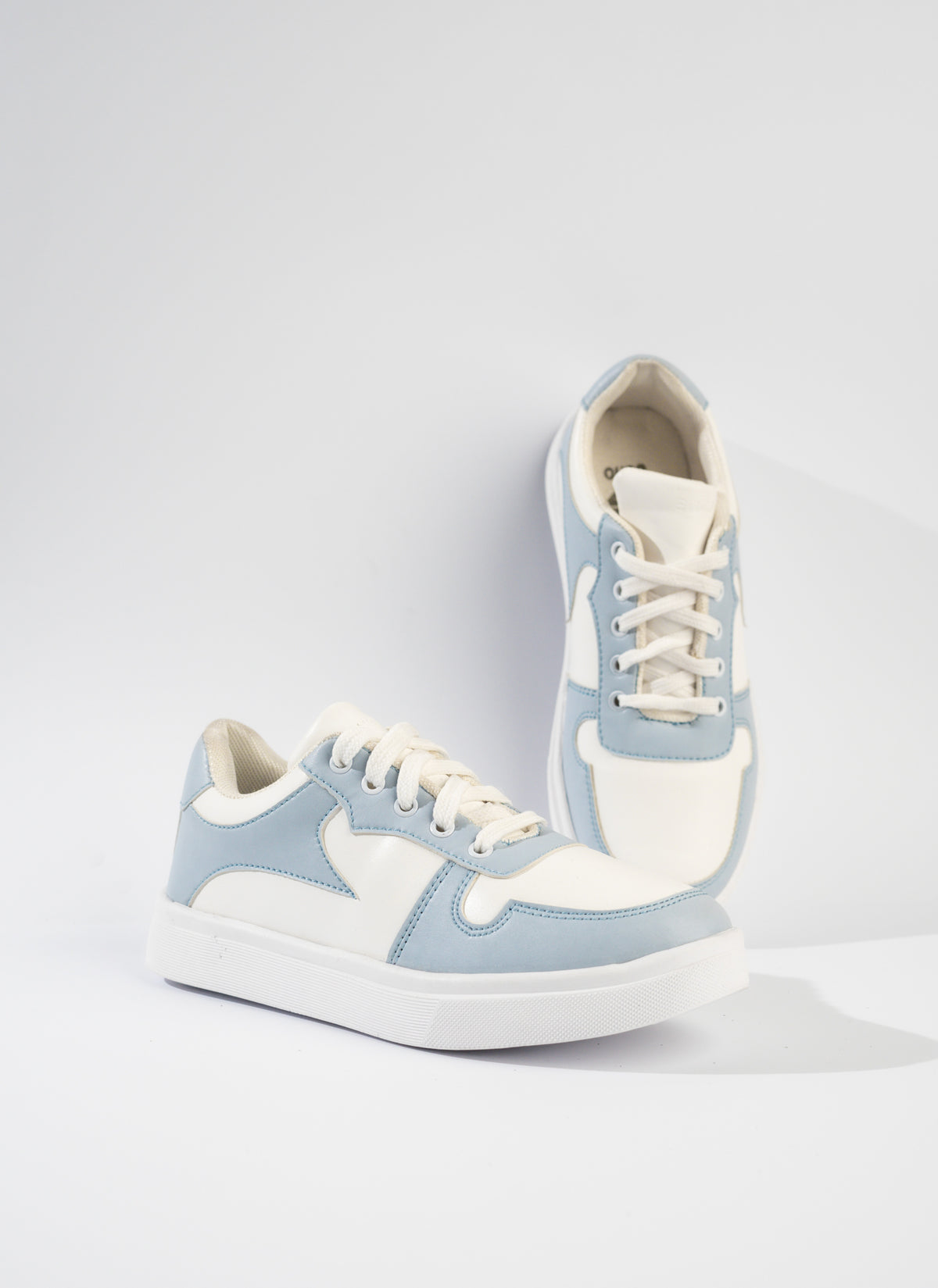 Pair of light blue and white sneakers on a white background