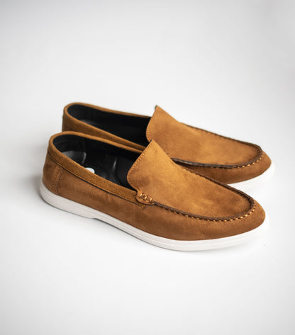 Pair of brown suede loafers on a white background