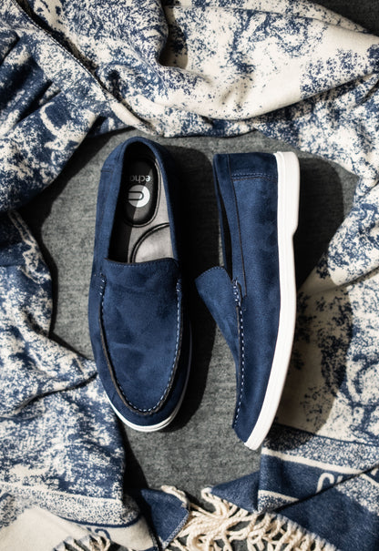 Pair of blue loafers on a textured fabric background