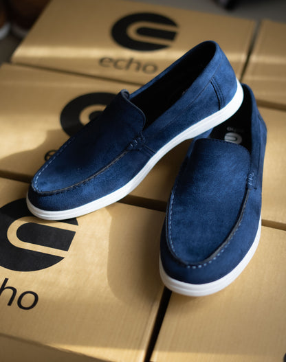 Blue loafers on a cardboard box with 'echo' branding