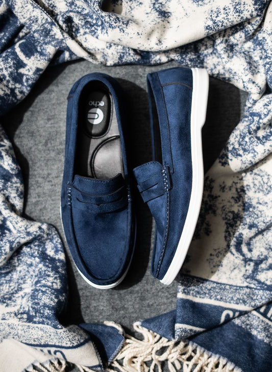 Pair of blue loafers on a textured fabric background