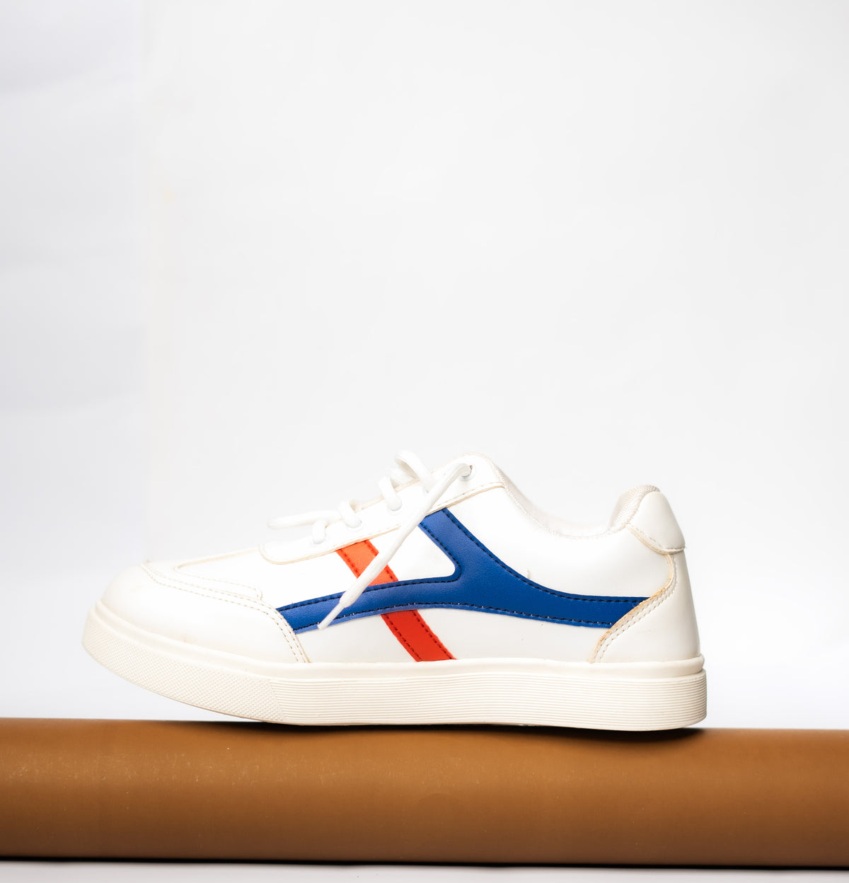 White sneaker with blue and red accents on a white background