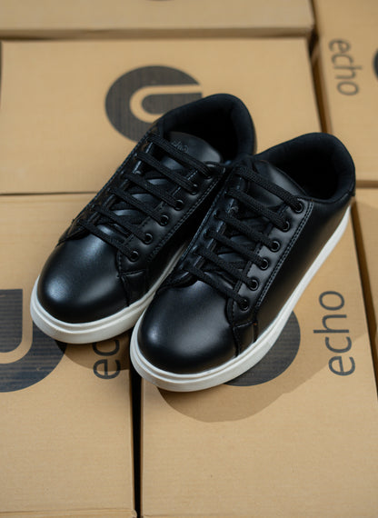 Black sneakers on a cardboard box with 'echo' branding