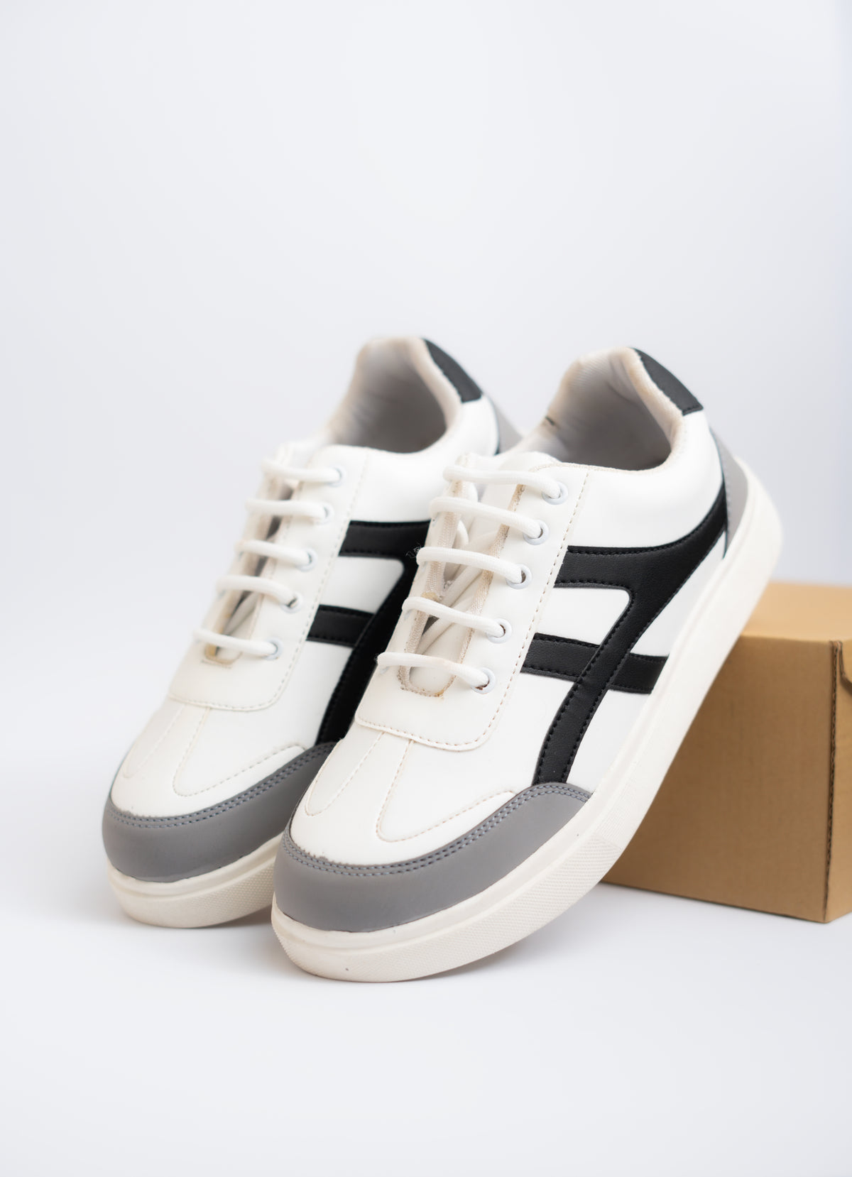 White and gray sneakers with black accents on a white background