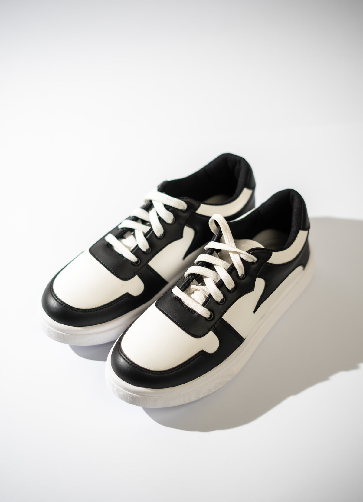 Black and white sneakers on a light gray background
