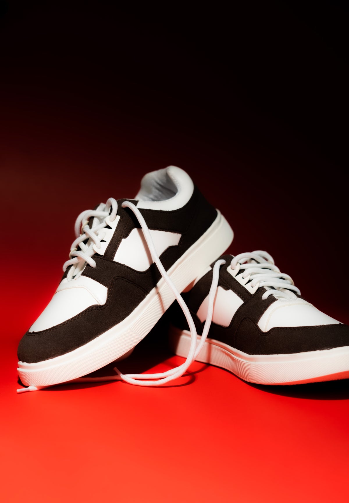 brown and white sneakers on a red background