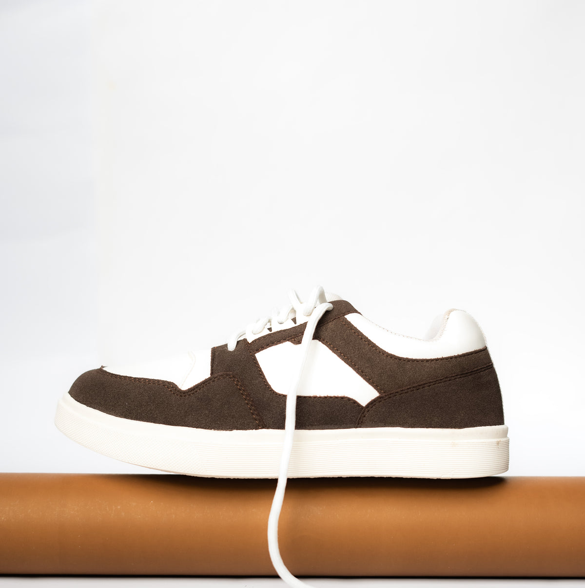 Brown and white sneaker on a light gray background