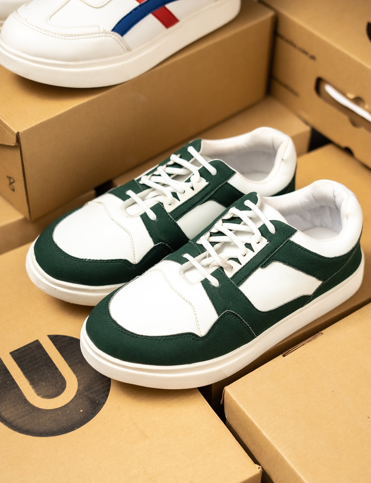 Green and white sneakers on cardboard boxes