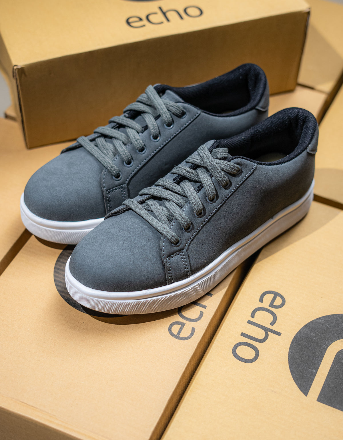Blue sneakers on a cardboard box with 'echo' branding