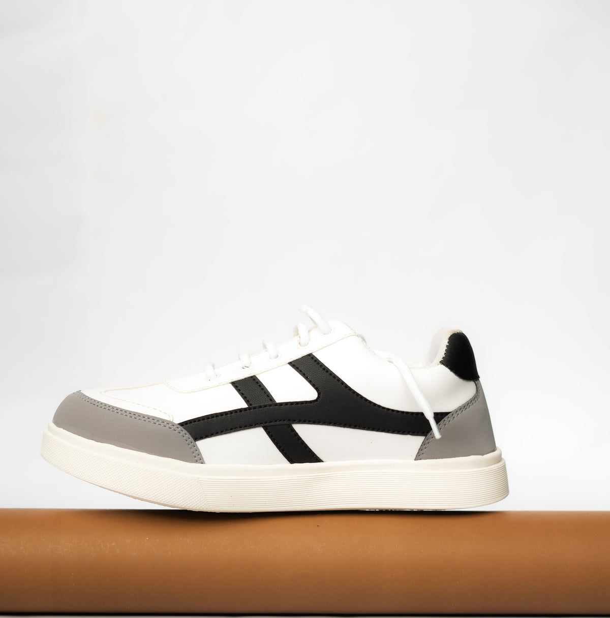 White sneaker with black and gray accents on a light gray background